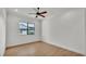 Bedroom showcasing ceiling fan, wood floors, a large window, and neutral paint throughout at 5087 Cliffside Drive, Lakeland, FL 33813