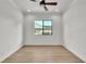 Bright bedroom with light hardwood floors, ceiling fan, and a window providing natural light at 5087 Cliffside Drive, Lakeland, FL 33813