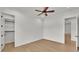 Light and airy bedroom showcasing ceiling fan, wood floors, and access to closet and other rooms at 5087 Cliffside Drive, Lakeland, FL 33813