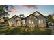 Twilight view of a beautiful home featuring a manicured lawn and a stone facade, creating a welcoming curb appeal at 5087 Cliffside Drive, Lakeland, FL 33813
