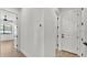 Hallway with neutral paint, hardwood floors, and multiple doors leading to various rooms at 5087 Cliffside Drive, Lakeland, FL 33813