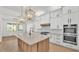 Gourmet kitchen with an island, stainless steel appliances, and elegant pendant lighting at 5087 Cliffside Drive, Lakeland, FL 33813