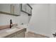 Laundry room featuring modern cabinetry, sink, and granite countertops at 5087 Cliffside Drive, Lakeland, FL 33813