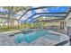 Backyard pool and spa enclosed in a screen with an outdoor kitchen at 5087 Cliffside Drive, Lakeland, FL 33813