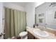 Bathroom with a sink, toilet, mirror, and shower with a green curtain at 5534 Turkey Creek Way, Lakeland, FL 33811