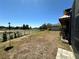 Expansive backyard with fence bordering the lake, enhanced by lush landscaping at 564 Meandering Way, Polk City, FL 33868