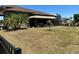 Backyard featuring an awning-covered lanai, palm trees, and black fence at 564 Meandering Way, Polk City, FL 33868