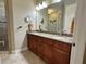 Bathroom features a double sink with dark wood cabinets and granite countertops at 564 Meandering Way, Polk City, FL 33868