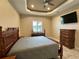 The bedroom has a decorative ceiling, window and mounted TV above dresser at 564 Meandering Way, Polk City, FL 33868