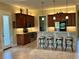 Kitchen showcasing a bar area, pendant lighting, tile backsplash, and ample cabinet space at 564 Meandering Way, Polk City, FL 33868