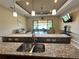 Granite countertop with double sink and a view of the living room and lanai at 564 Meandering Way, Polk City, FL 33868
