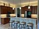 Kitchen boasts a bar area, stainless steel appliances, and a view into the laundry room at 564 Meandering Way, Polk City, FL 33868