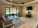Bright living room featuring tile flooring, ceiling fan, and sliding glass doors to the lanai at 564 Meandering Way, Polk City, FL 33868