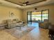 Living room featuring tile floors, modern furnishings, and a seamless indoor-outdoor flow at 564 Meandering Way, Polk City, FL 33868