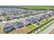 A shot shows many similar homes in the neighborhood near a wooded area in the distance at 613 Sarner Pass Way, Winter Haven, FL 33881