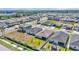 An aerial view showcases modern homes in a peaceful neighborhood setting with tree-lined streets at 613 Sarner Pass Way, Winter Haven, FL 33881