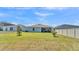 Spacious backyard with green grass, privacy fence, and a screened patio at 613 Sarner Pass Way, Winter Haven, FL 33881
