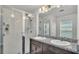 Modern bathroom featuring double sinks, granite countertops, and a sleek glass-enclosed shower at 613 Sarner Pass Way, Winter Haven, FL 33881