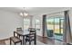 Cozy dining area with natural light, featuring a wood table with seating for four and access to the backyard at 613 Sarner Pass Way, Winter Haven, FL 33881