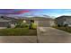 Charming single-story home with a two-car garage, lush landscaping, and a well-manicured lawn at 613 Sarner Pass Way, Winter Haven, FL 33881
