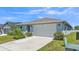 Charming single-story home with a two-car garage, lush landscaping, and a well-manicured lawn at 613 Sarner Pass Way, Winter Haven, FL 33881