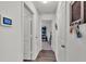 Hallway with hardwood floors, a digital display, and doors leading to various rooms in the home at 613 Sarner Pass Way, Winter Haven, FL 33881