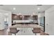 Stylish kitchen featuring granite countertops, dark wood cabinetry, and stainless steel appliances at 613 Sarner Pass Way, Winter Haven, FL 33881