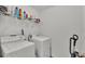 Functional laundry room with modern washer, dryer, shelving and cleaning equipment at 613 Sarner Pass Way, Winter Haven, FL 33881