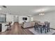 Spacious living room and dining area featuring hardwood floors, modern lighting, and an open-concept design at 613 Sarner Pass Way, Winter Haven, FL 33881