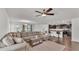 Open-concept living room and kitchen area, with a large sectional sofa and bar seating at the kitchen counter at 613 Sarner Pass Way, Winter Haven, FL 33881