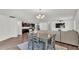 Open-concept living room with dining area, modern lighting, and a view of the kitchen with stainless steel appliances at 613 Sarner Pass Way, Winter Haven, FL 33881