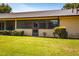 Charming backyard with a lush green lawn, mature landscaping, and a screened-in porch for enjoying the outdoors at 697 Broadmoor Cir, Winter Haven, FL 33884