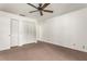 A carpeted bedroom with white walls, ceiling fan and large closet at 697 Broadmoor Cir, Winter Haven, FL 33884
