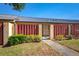 Inviting front entrance with a courtyard, secure gate, mature landscaping, and metal roof at 697 Broadmoor Cir, Winter Haven, FL 33884