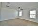 This bedroom features neutral carpet, a ceiling fan, and two windows at 752 Reggie Rd, Winter Haven, FL 33884