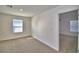 This bedroom has neutral carpet, a window, and a doorway to another room at 752 Reggie Rd, Winter Haven, FL 33884