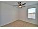 This bedroom features neutral carpet, a ceiling fan, and a window at 752 Reggie Rd, Winter Haven, FL 33884