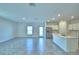Spacious living area features tiled flooring, stainless steel appliances, and a modern kitchen with an island at 752 Reggie Rd, Winter Haven, FL 33884