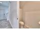 Compact powder room with a toilet and a pedestal sink with a mirror, adjacent to the hallway and stairs at 752 Reggie Rd, Winter Haven, FL 33884