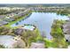 Aerial view showing community amenities including pool, clubhouse, and a picturesque lake at 7779 Lake James Blvd, Lakeland, FL 33810