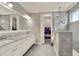 Bright bathroom with double vanity, a glass-enclosed shower, and a walk-in closet visible through an open door at 7779 Lake James Blvd, Lakeland, FL 33810