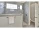 This bathroom features a glass-enclosed shower with gray tiles, a window, and a door leading to another room at 7779 Lake James Blvd, Lakeland, FL 33810