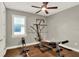 Workout room featuring hardwood floors, a ceiling fan, window with blinds, and exercise equipment at 7779 Lake James Blvd, Lakeland, FL 33810