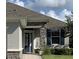 Close up of home's exterior featuring the front door and a window with blue shutters and lovely stone facade at 7779 Lake James Blvd, Lakeland, FL 33810