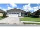 Single Gathering home boasting manicured lawn, paved driveway, stone accents, and a two car garage at 7779 Lake James Blvd, Lakeland, FL 33810