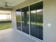 A screened lanai featuring a ceiling fan, sliding glass doors, and views of the backyard at 7779 Lake James Blvd, Lakeland, FL 33810