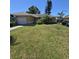 Charming ranch home with an attached garage, lush lawn, palms, an RV, and a car parked in the driveway at 7818 Lewis Rd, Lakeland, FL 33810