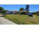 Charming ranch home with an attached garage, lush lawn, palms, an RV, and a car parked in the driveway at 7818 Lewis Rd, Lakeland, FL 33810
