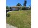 Charming ranch home with an attached garage, lush lawn, palms, an RV, and a car parked in the driveway at 7818 Lewis Rd, Lakeland, FL 33810