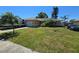 Charming ranch home with an attached garage, lush lawn, palms, an RV, and a car parked in the driveway at 7818 Lewis Rd, Lakeland, FL 33810